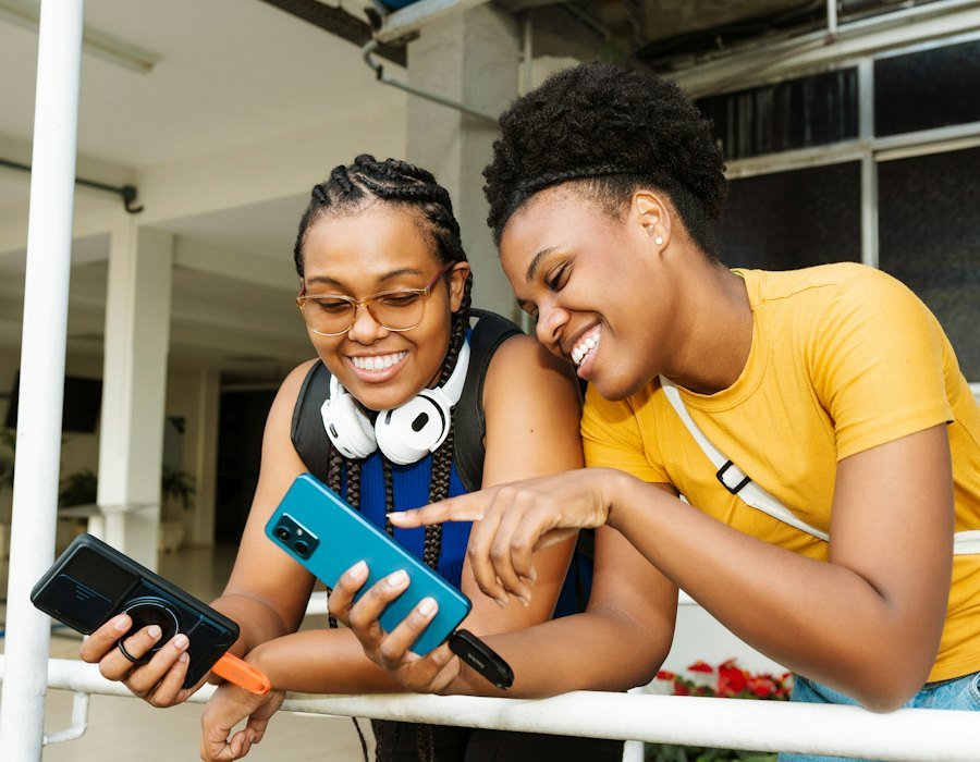 Deux jeunes femmes rient devant un smartphone